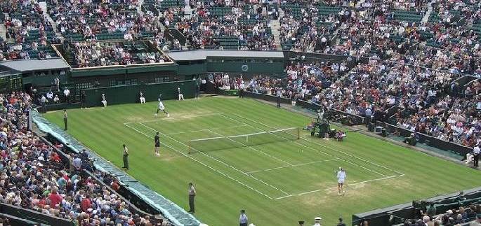 image of a large crowd at one of wimbledon's tennis courts watching the ladies at play