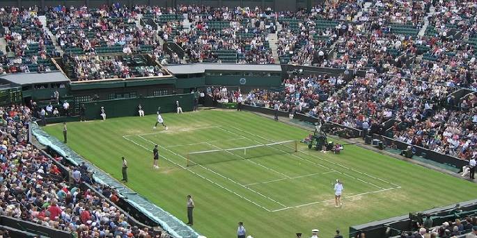 image of a large crowd at one of wimbledon's tennis courts watching the ladies at play