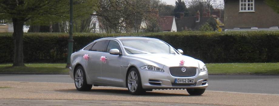 jaguar xj wedding car with white front ribbon and pink decoration on doors