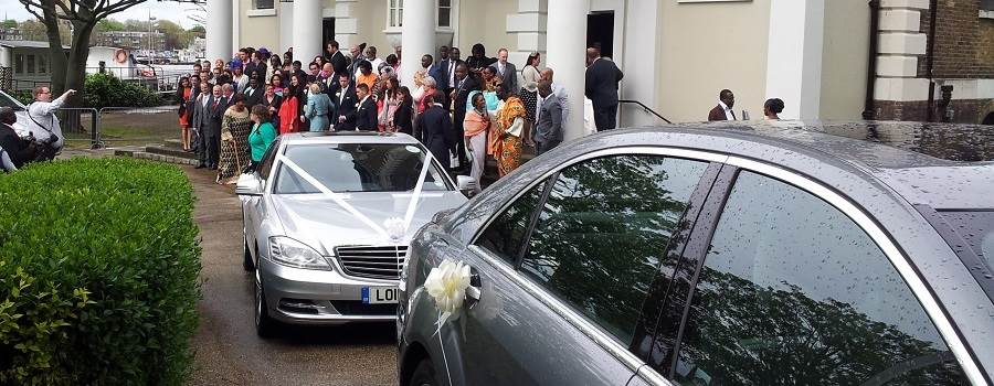 bride and her family standing beside their mercedes wedding chauffeur car