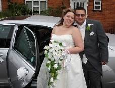 image of a wedded couple beside a wedding chauffeur car